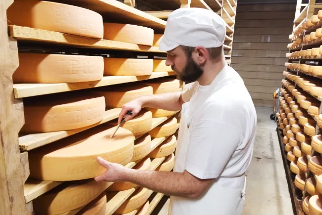 Cédric Descloux en train d'effectuer des contrôles de qualité sur les fromages en cave